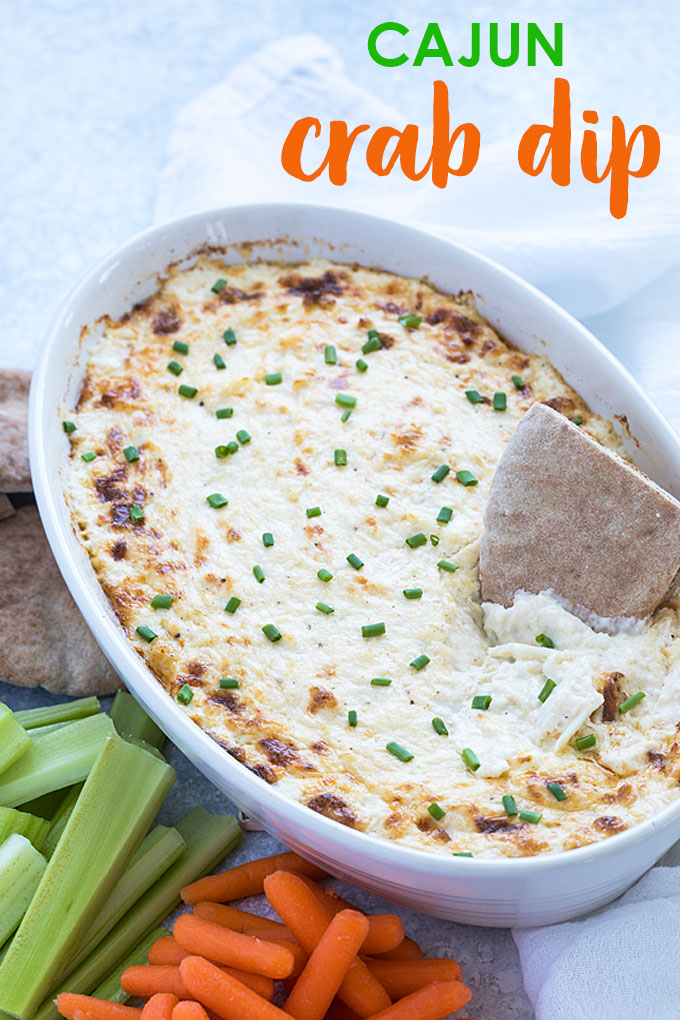Crab dip in an oval white baking dish. Overlay text at top of image.