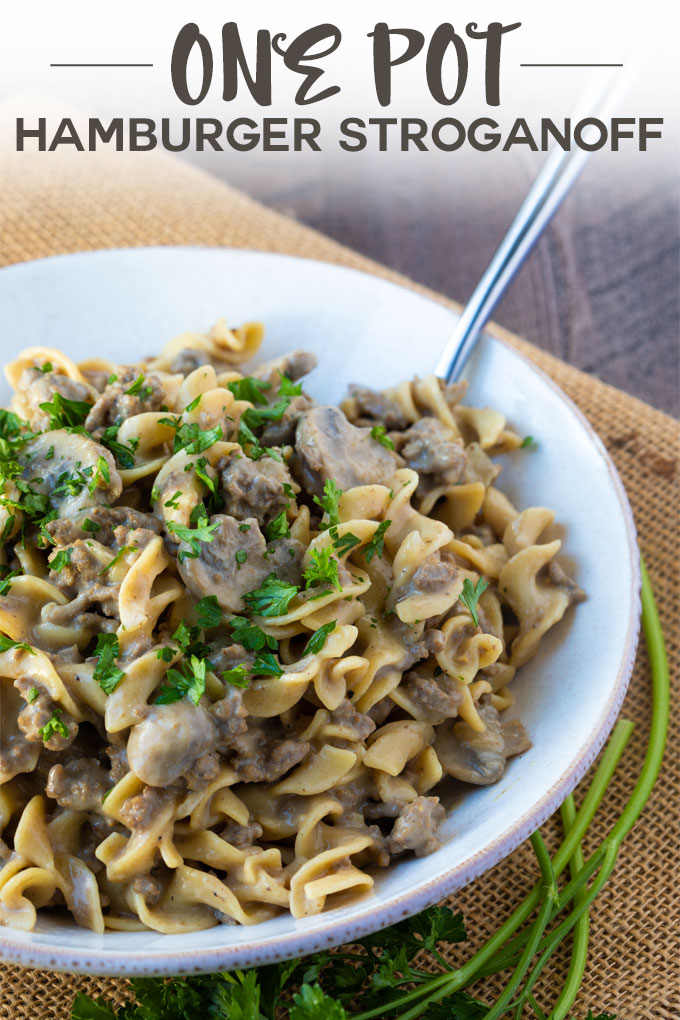 Hamburger stroganoff in a white bowl with a fork.  Overlay text at top of image.