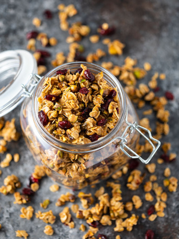 Overhead view of homemade granola in an opened glass canister.