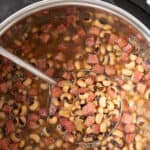Black eyed peas in an Instant Pot with a ladle. Overlay text at top of image.