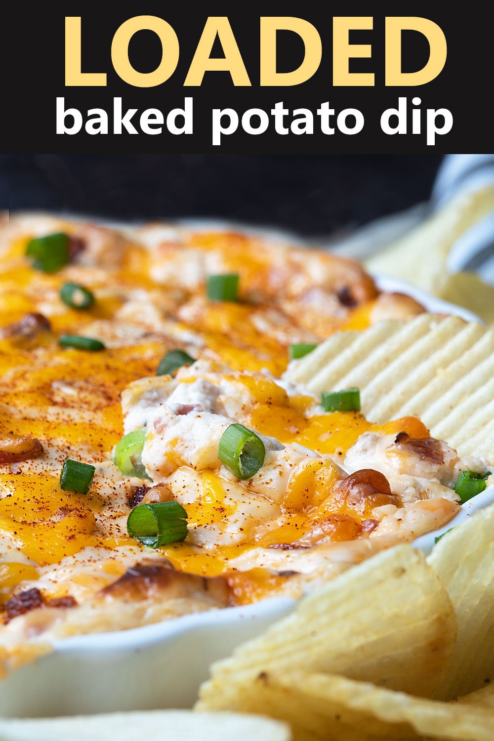 Loaded baked potato dip spread on a potato chip.