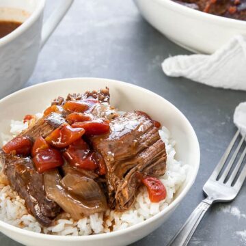 A bowl of rice topped with Italian Pot Roast and gravy cooked in the pressure cooker