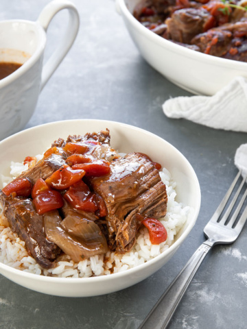 A bowl of rice topped with Italian Pot Roast and gravy cooked in the pressure cooker