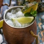 A closeup of a pineapple mule in a copper mug with crushed ice