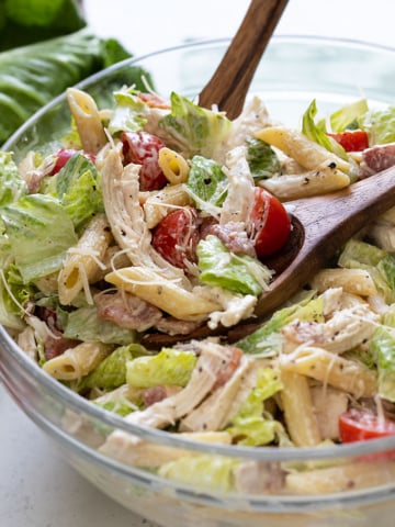 Closeup of Chicken Caesar Pasta Salad in a clear glass bowl