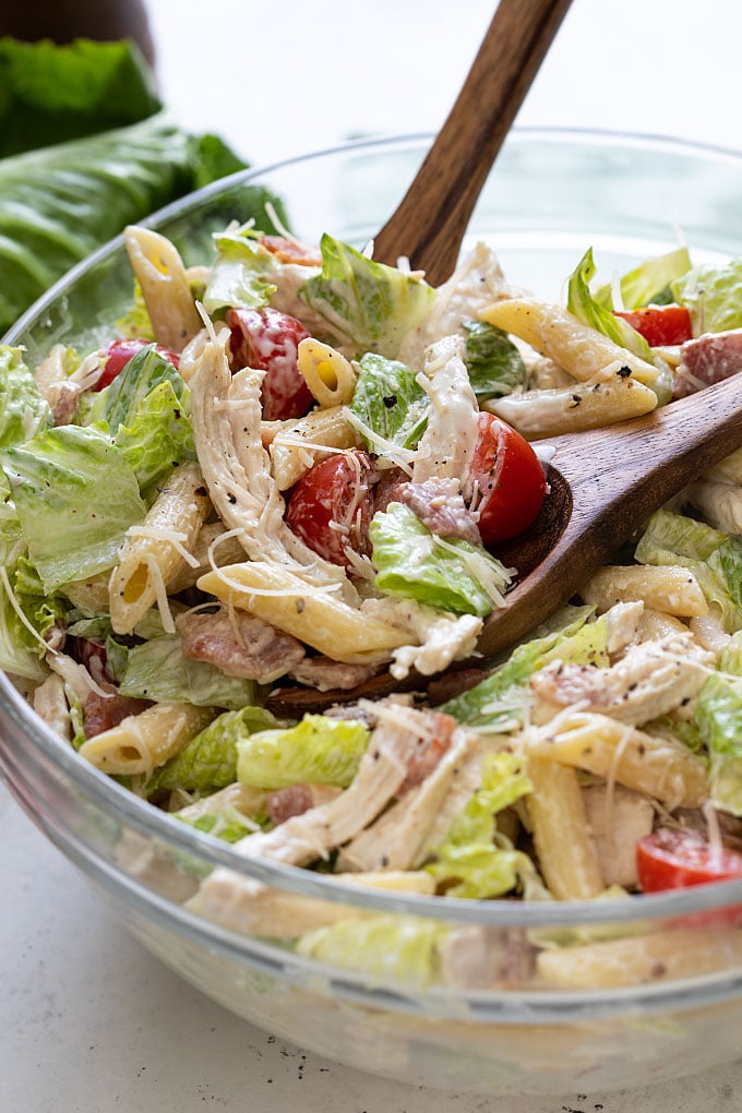 Closeup of Chicken Caesar Pasta Salad in a clear glass bowl.