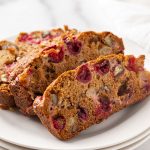 3 slices of cranberry apple nut bread on a round white plate
