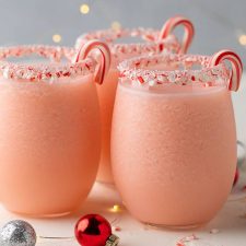3 peppermint pina coladas in glasses rimmed with crushed candy canes