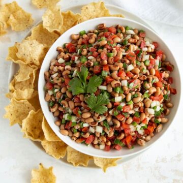 Overhead view of Black-Eyed Pea Salsa in a white bowl with tortilla chips
