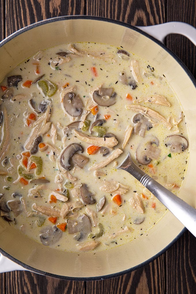 Creamy turkey and mushroom soup in a white dutch oven with a ladle