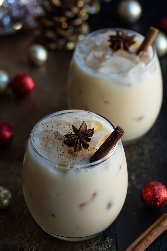Two white russian cocktails garnished with star anise and cinnamon sticks.