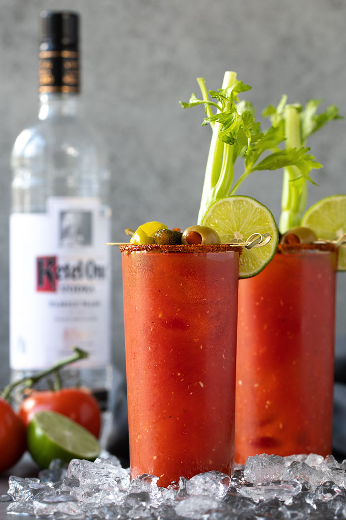 Front view of two garnished bloody mary cocktails.