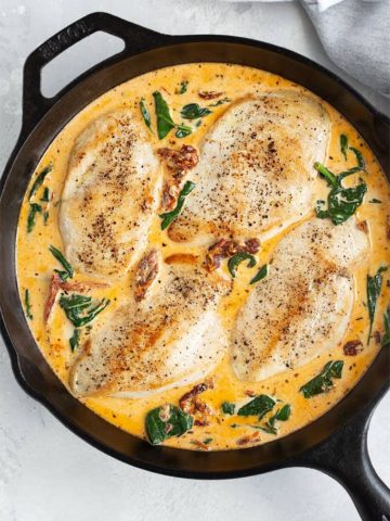 Overhead shot of creamy Tuscan chicken in a cast iron skillet
