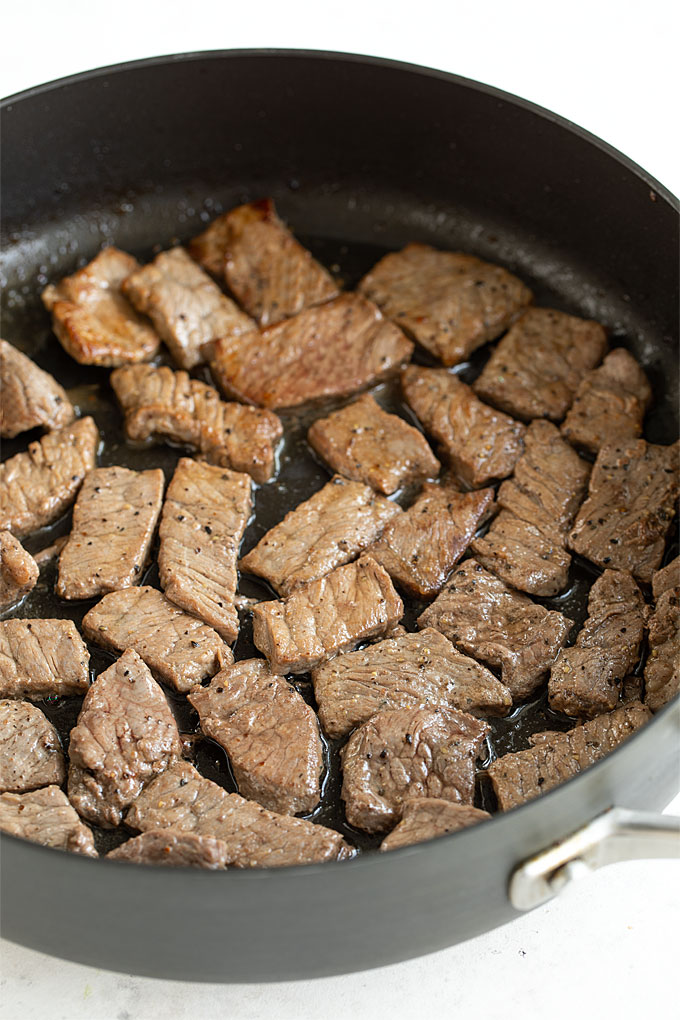 Thinly sliced cooked sirloin in a skillet