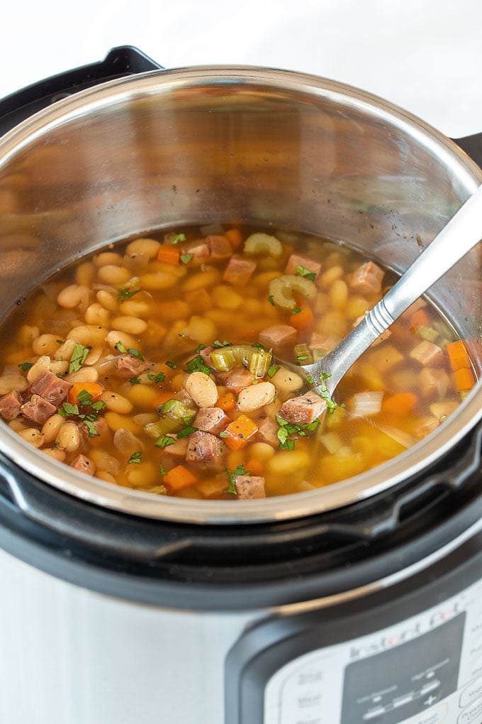 Ham and bean soup in an instant pot with a stainless ladle