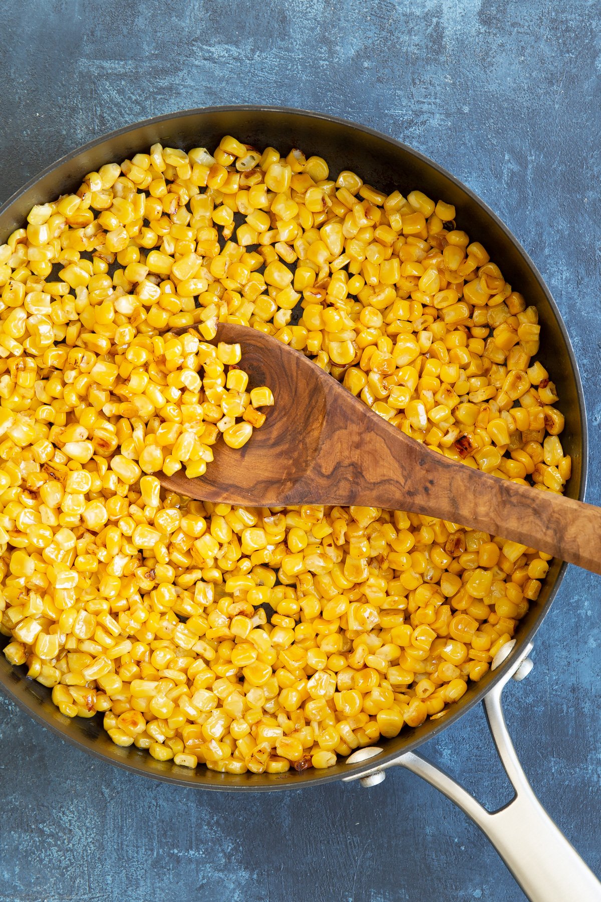Overhead view of cooked yellow corn kernels in a skillet.