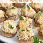 Crab Stuffed Mushrooms on an oval white platter with overlay text.
