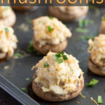 A closeup of stuffed mushrooms on a baking sheet with overlay text.