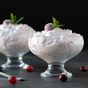 Two dishes of cranberry fluff salad garnished with fresh mint sprigs.