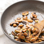 Sauteed mushrooms in a skillet with a wooden spoon. Overlay text at top of image.