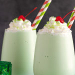 Front view of two boozy shamrock shakes with overlay text.