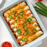 Overhead view of easy ground beef enchiladas in a baking dish.