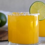 Front view of two mango margaritas with overlay text.