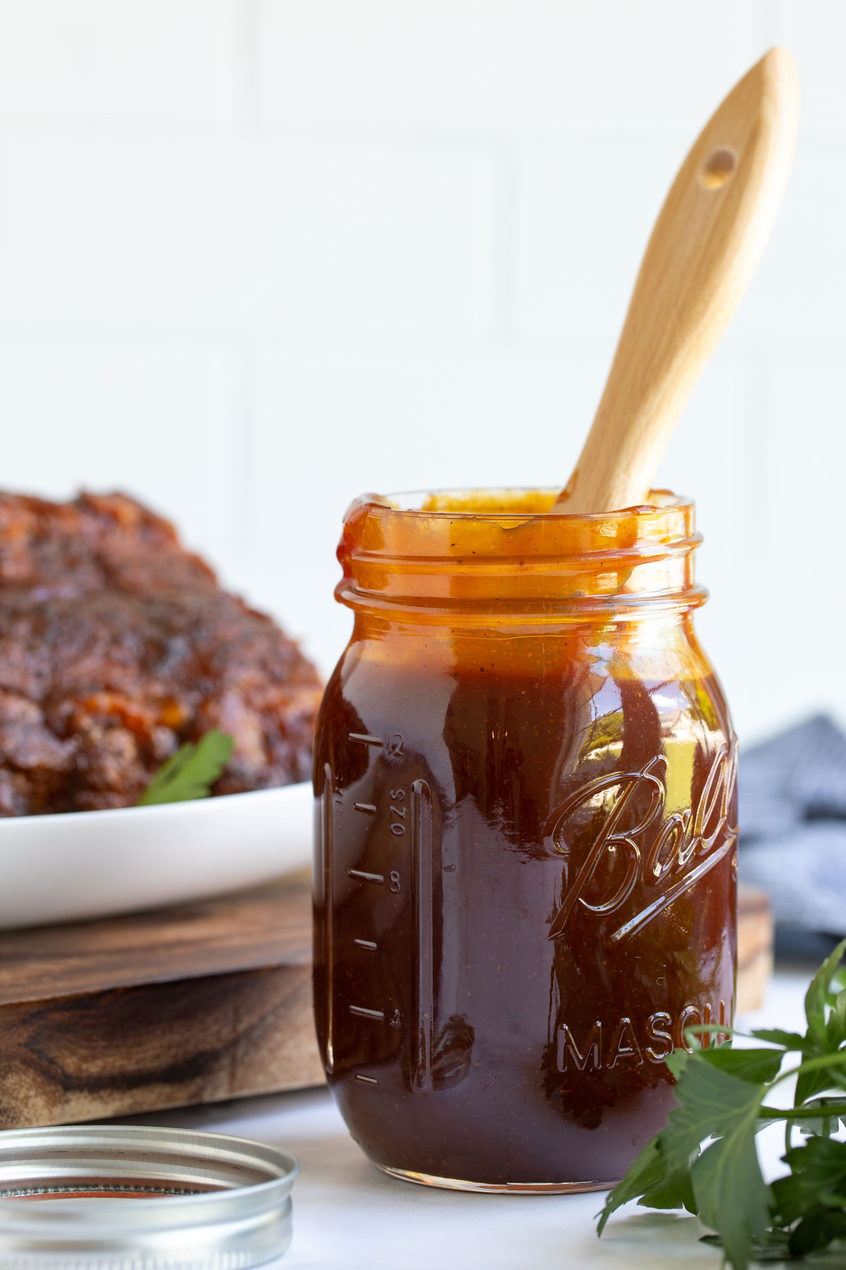 Front view of barbecue sauce in a jar with a basting brush in the jar.