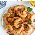 Old Bay Shrimp in a white plate with overlay text at the top of image.
