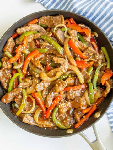 Overhead view of Chinese pepper steak and onions in a skillet.