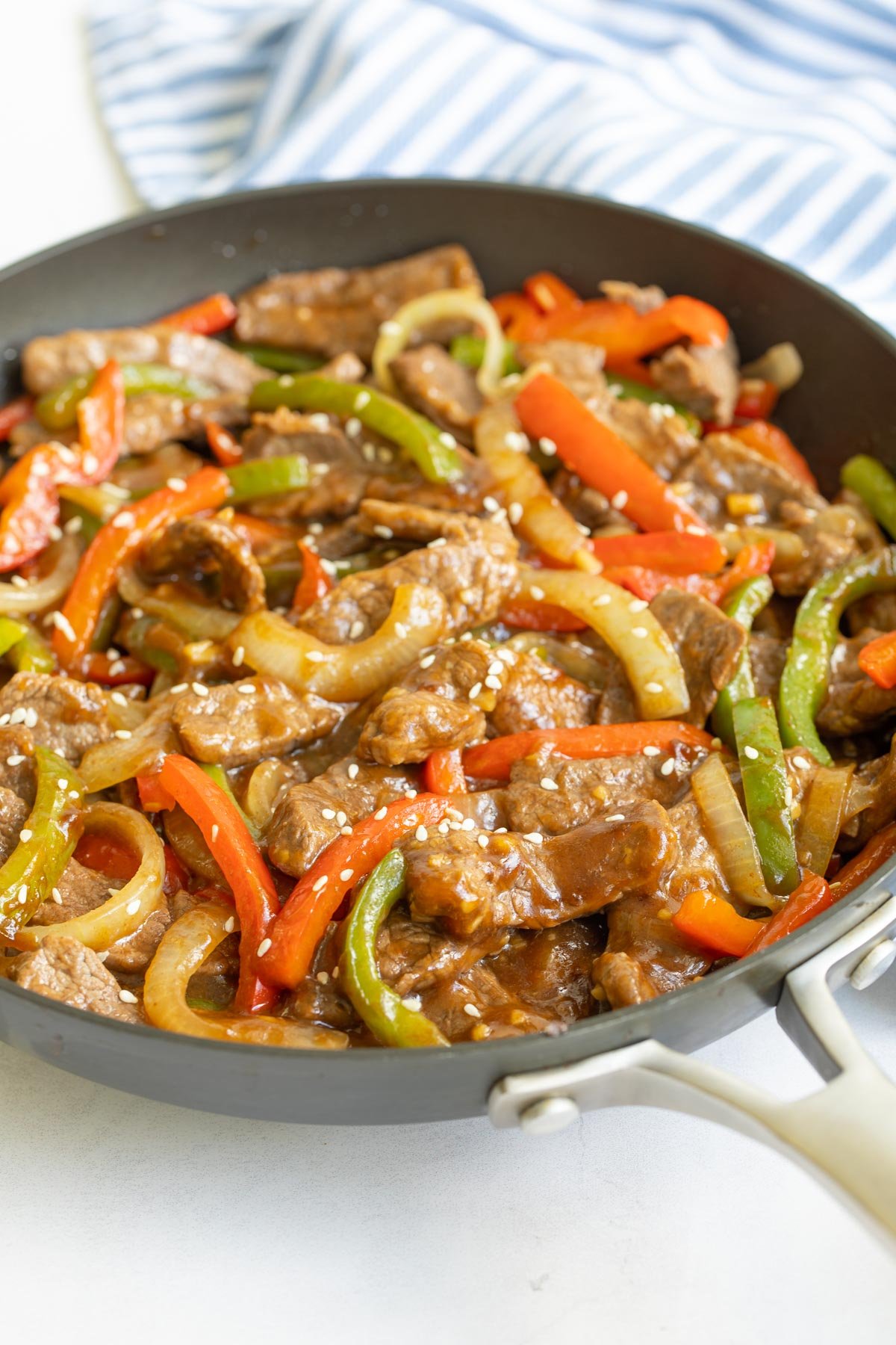 Front closeup view of Chinese pepper steak and onions in a skillet.