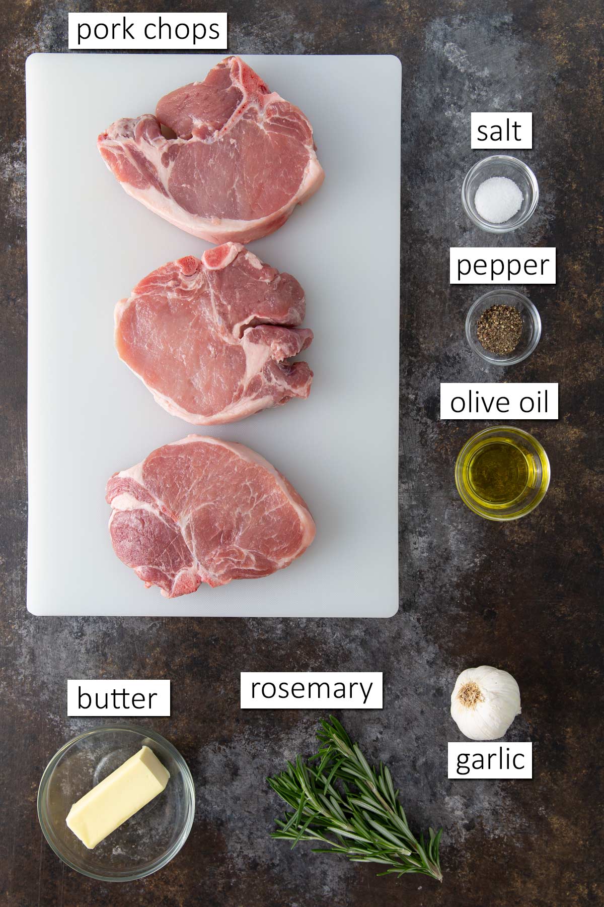 Overhead view of ingredients for baked pork chops with rosemary and garlic.