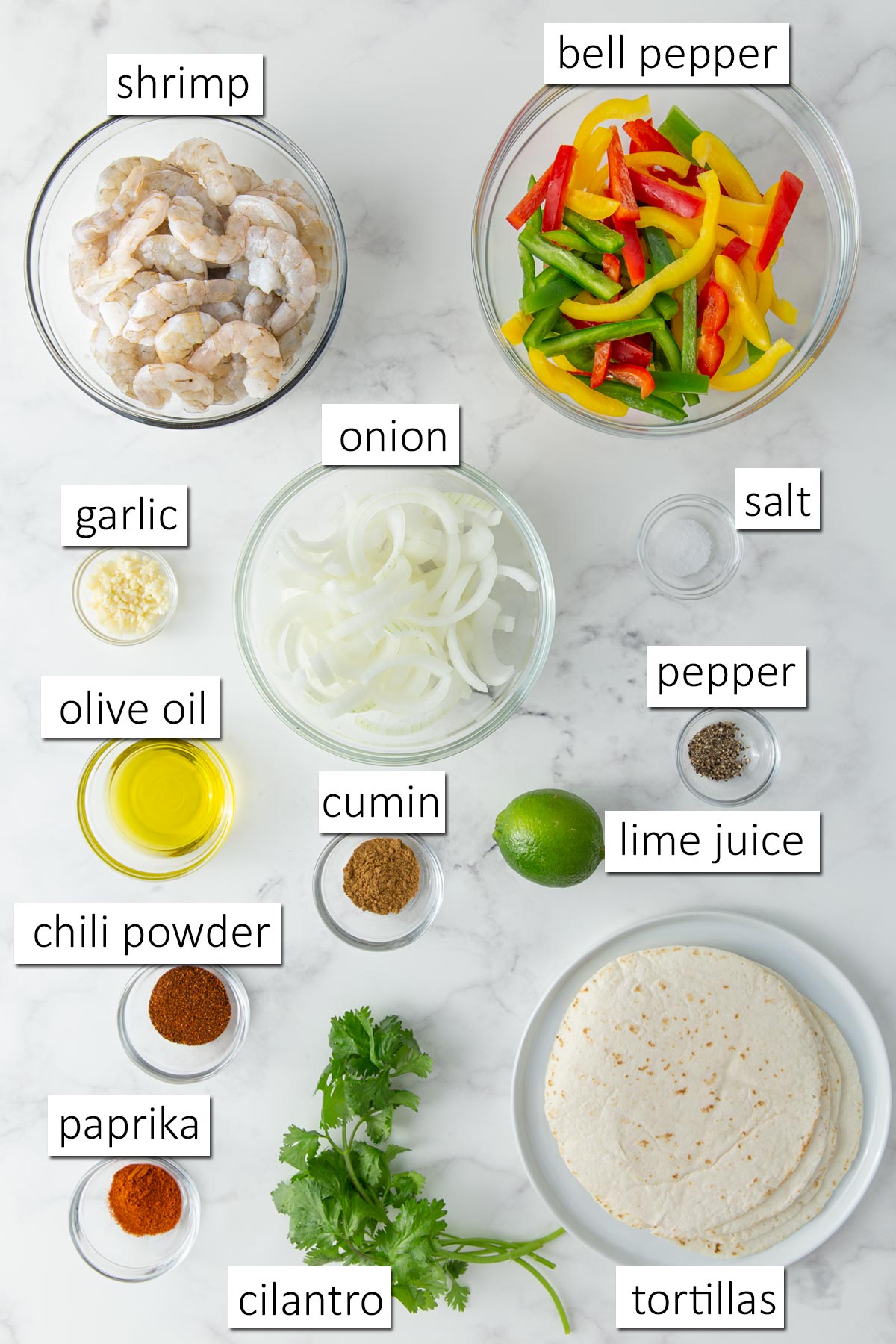 Overhead view of ingredients for sheet pan shrimp fajitas with overlay text.