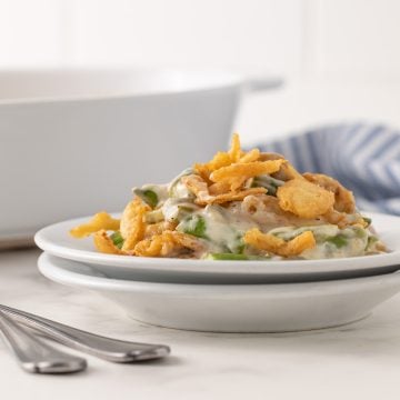 Front view of a serving of green bean casserole on a white plate.