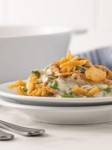 Front view of a serving of green bean casserole on a white plate.