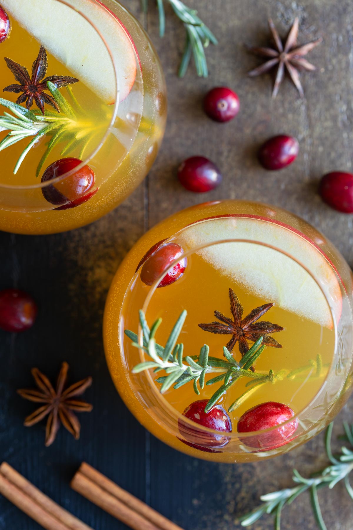 Overhead view of two glasses of sangria garnished with rosemary sprigs.