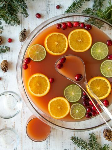 Overhead view of a bowl of garnished Christmas punch with a ladle.