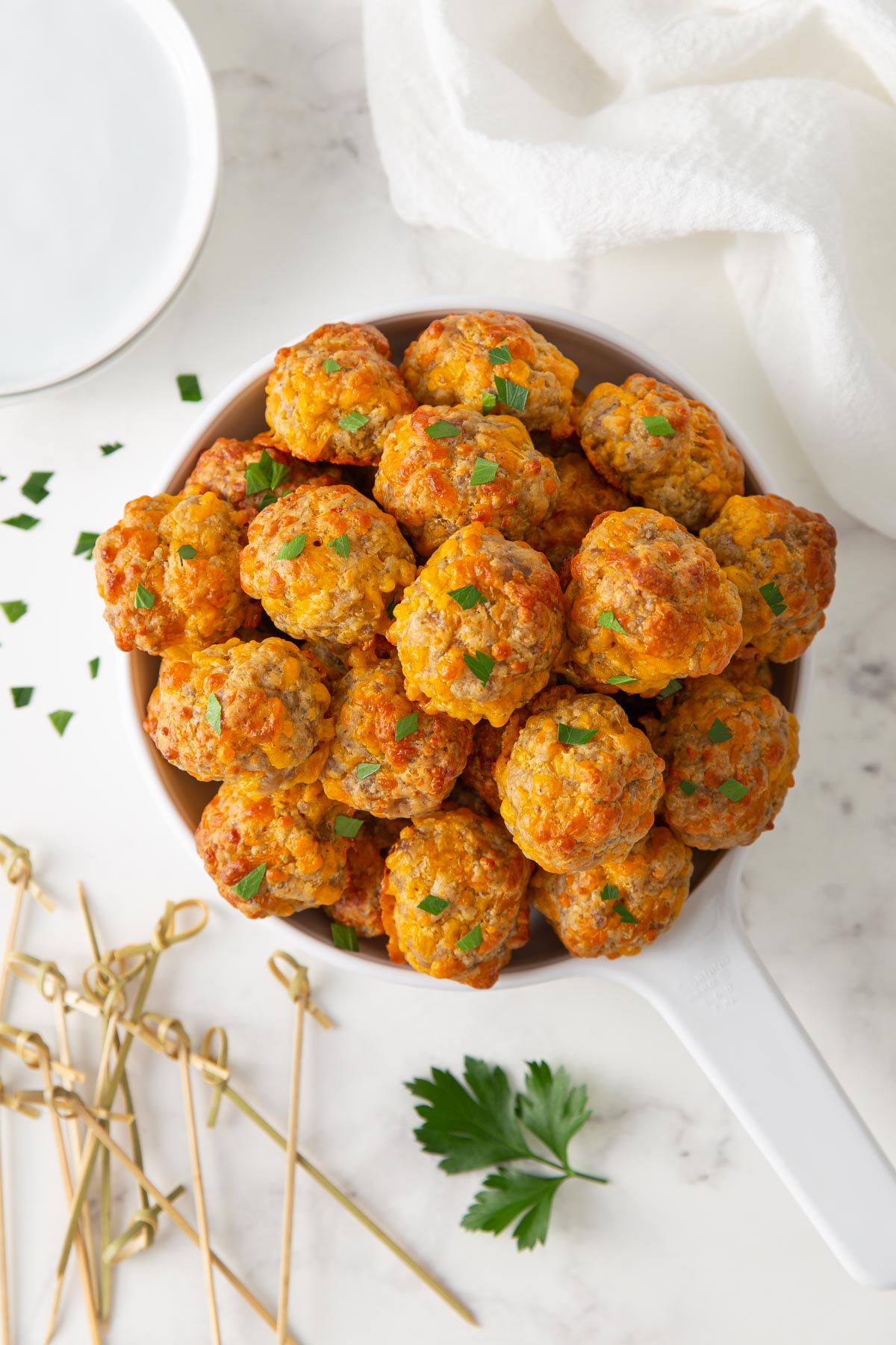Overhead view of sausage cheese balls in a white serving dish.