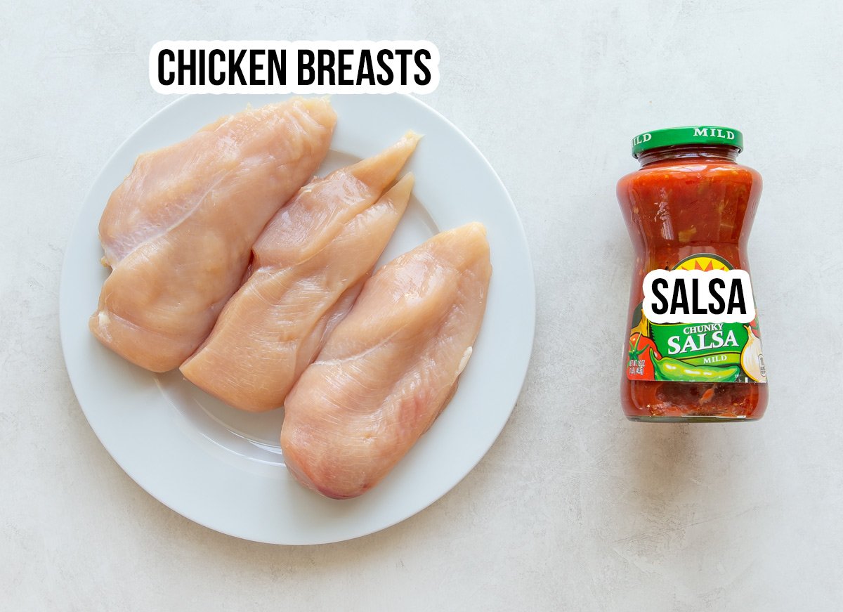 Overhead view of boneless, skinless chicken breasts and a jar of salsa for crockpot salsa chicken.