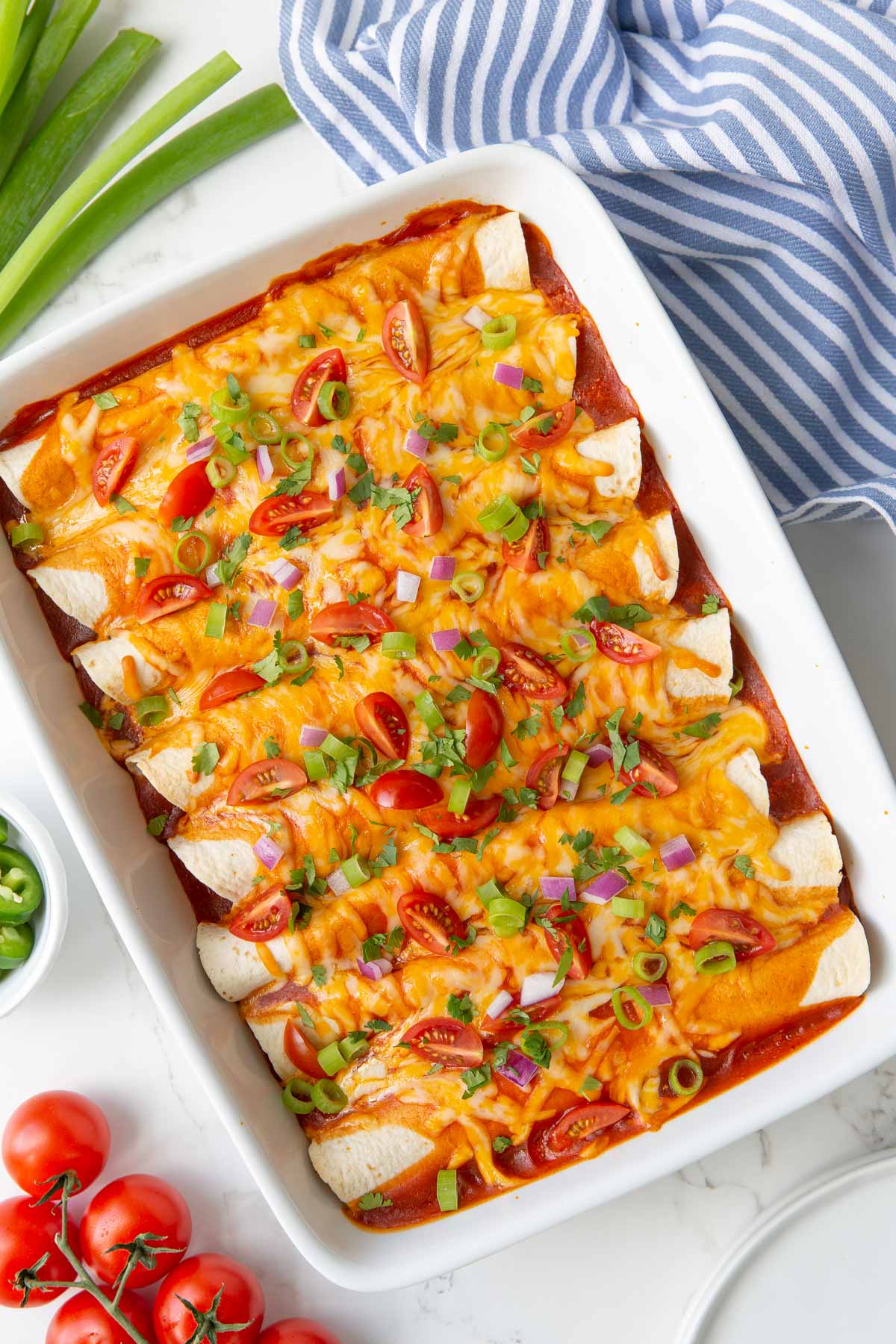 Overhead view of shredded beef enchiladas in a white baking dish.