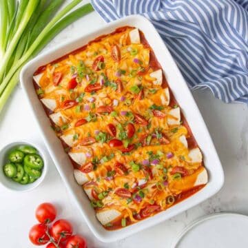 Overhead view of shredded beef enchiladas in a white baking dish.