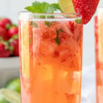 A garnished strawberry mojito in a glass. Overlay text is at top of image.