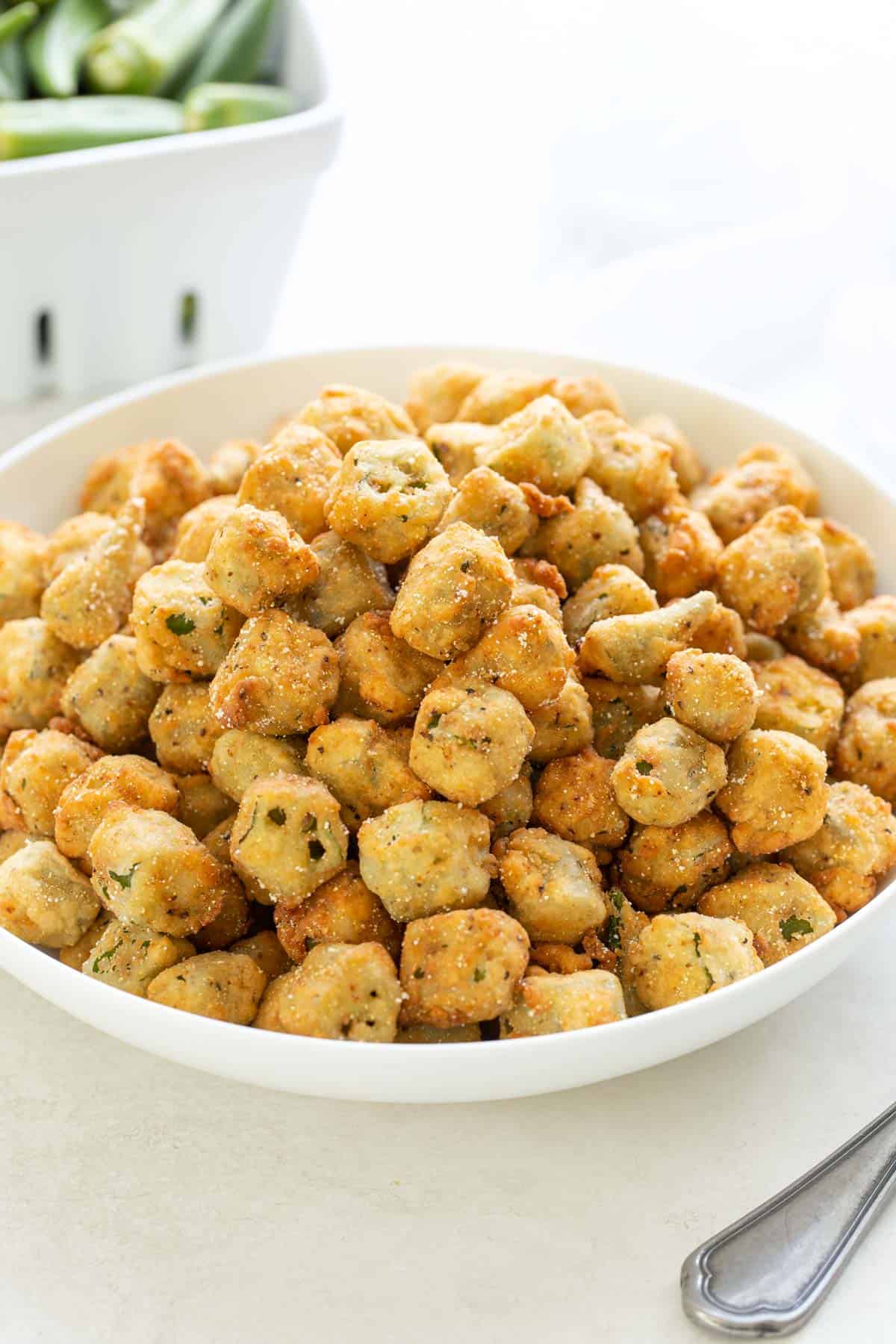 Front closeup view of breaded fried okra in a white bowl.