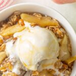 Overhead view of apple crisp topped with ice cream. Overlay text at top of image.