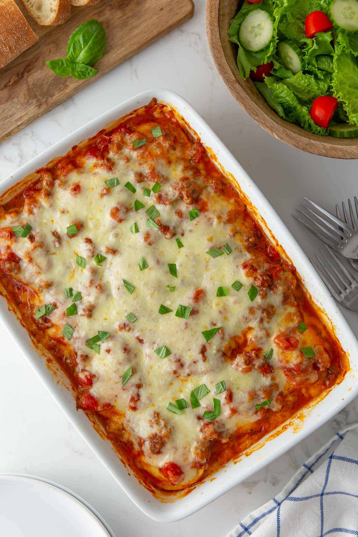 Overhead view of baked ravioli in a white baking dish.
