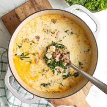 Overhead view of zuppa toscana soup being ladled from a Dutch oven.