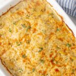Scalloped potatoes in a white baking dish. Overlay text at top of image.