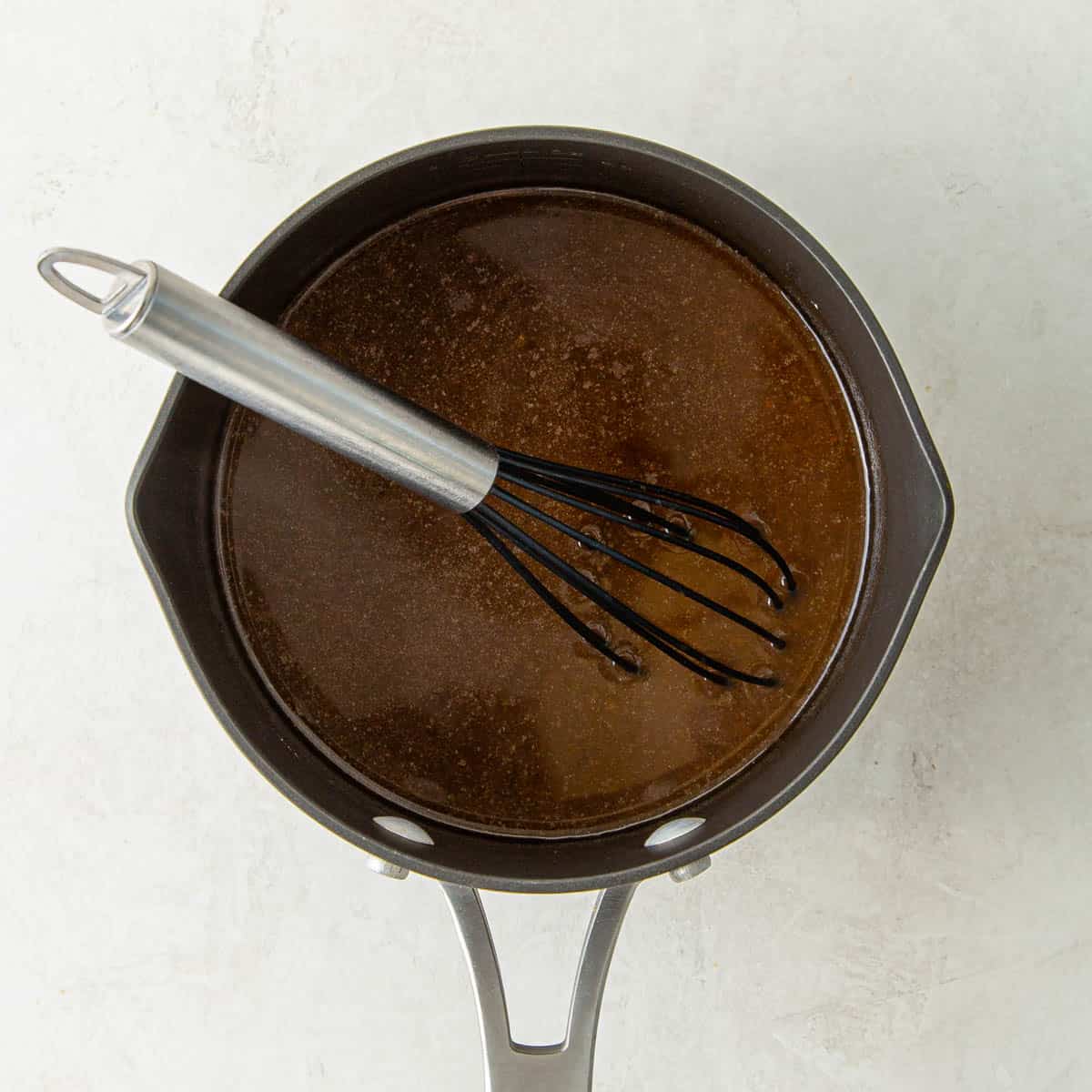 A saucepan with au jus for boneless prime rib.