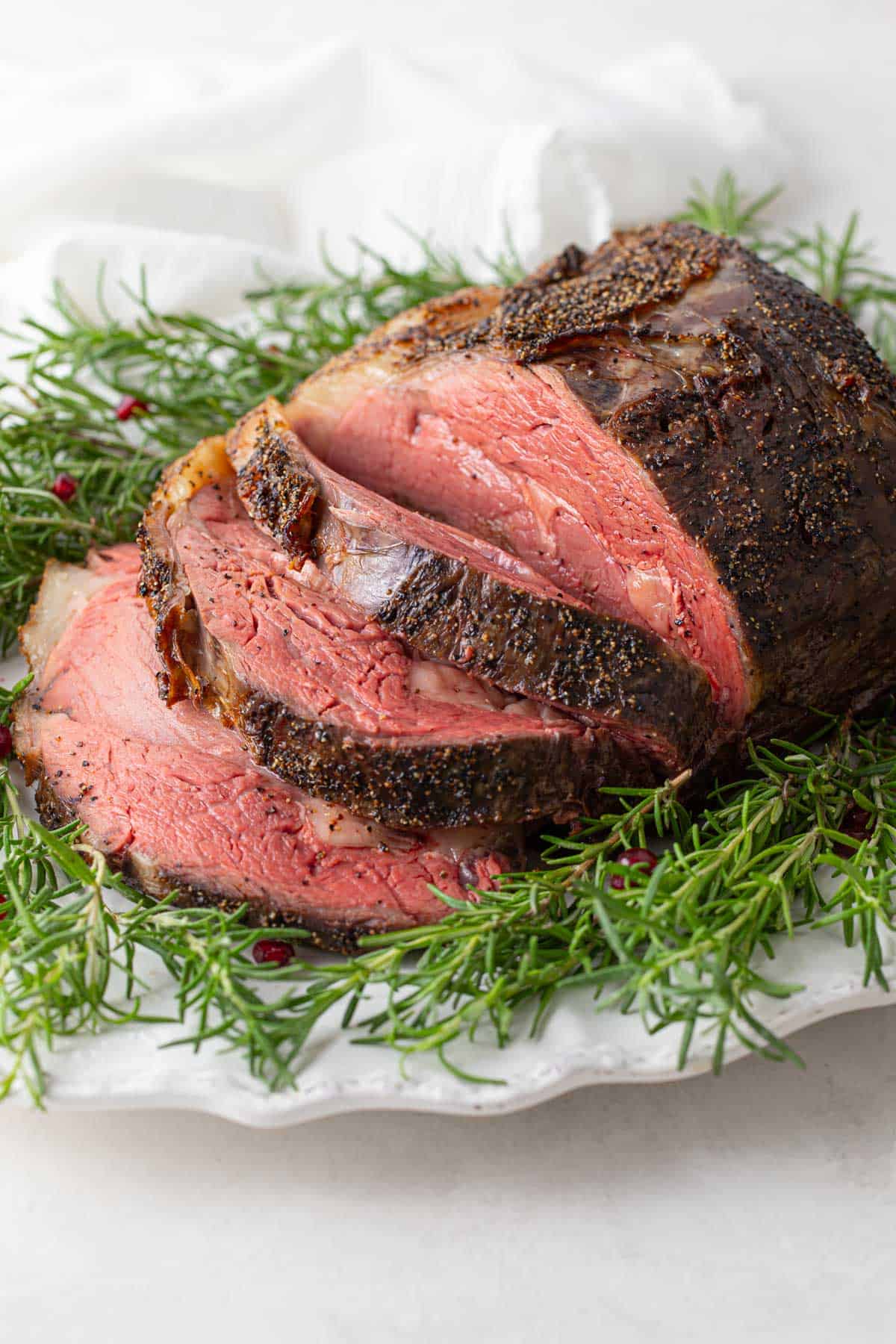 Front view of a roasted and sliced  boneless prime rib on a serving platter.