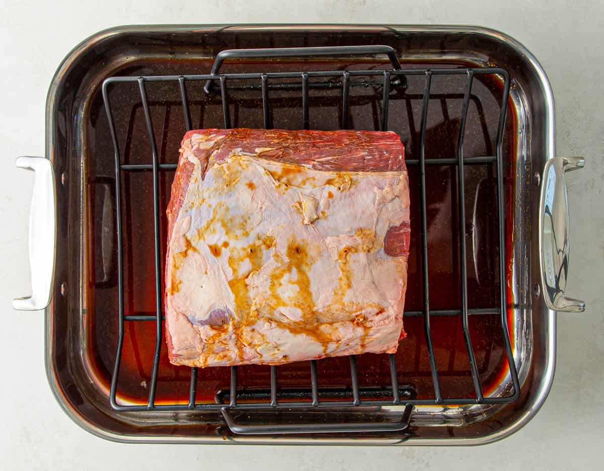Overhead view of a boneless prime rib on a roasting rack in a roasting pan.